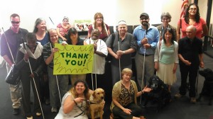 Society for the Blind staff and clients grouped in the lobby, holding a bright neon Thank You sign