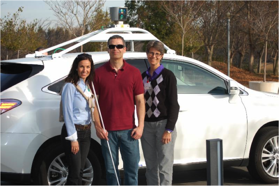 Society for the Blind's Liz Culp, Shane Snyder, and Shari Roeseler standing in front of the white Lexus self-driving car by Google