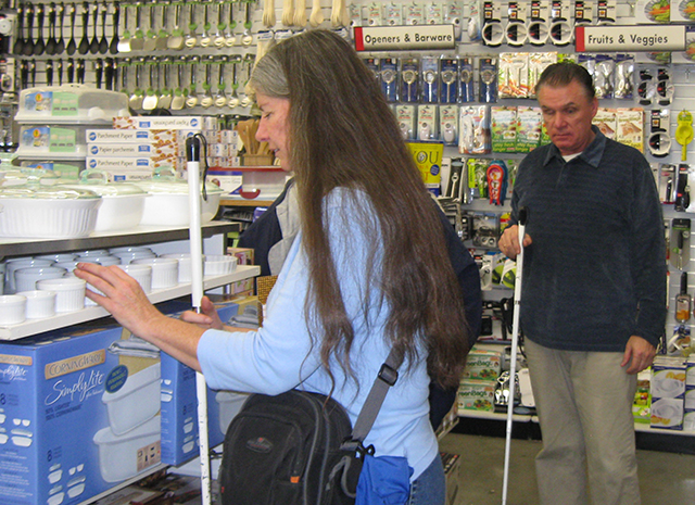 an image of a man and woman couple shopping in a Bed Bath and Beyond with their white canes