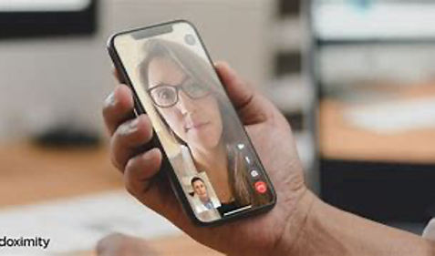 A woman with brown hair having a telemedicine appointment with her doctor via her iPhone