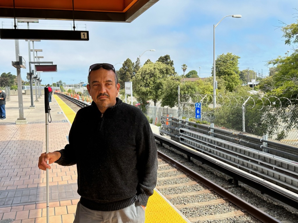 Robert Edwards stands with his cane at the lightrail station