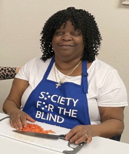 Trena King wearing a blue Society for the Blind apron in the SIP teaching kitchen