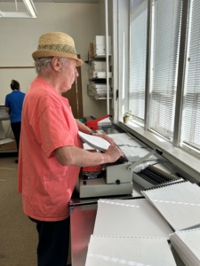Photo of: Dan working with comb binding machine
